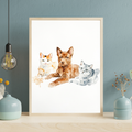 Framed watercolor portrait of a brown dog sitting between two cats, displayed on a wooden shelf in a cozy room.