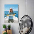 A framed portrait of a smiling woman in a blue shirt holding a fish on a boat, displayed in a