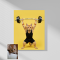 A framed wall print of a custom digital portrait featuring an orange tabby cat as a powerlifter wearing black workout