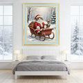 Framed oil painting of a cat dressed as Santa Claus riding a red sleigh with a reindeer in a snowy