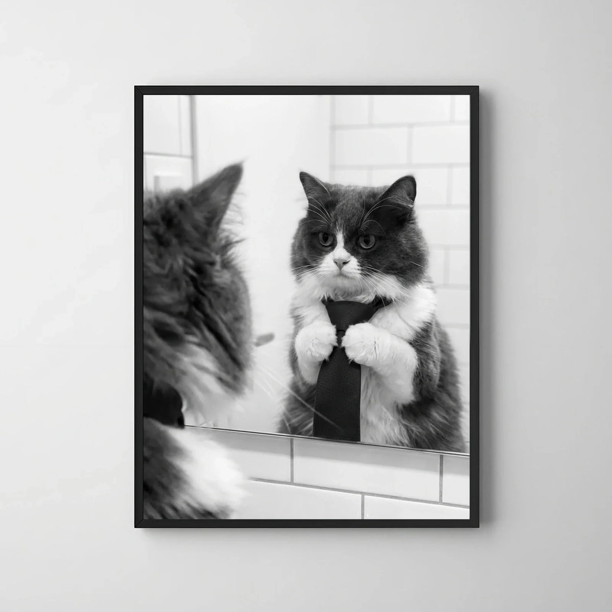 Framed print of a black and white portrait featuring a fluffy cat adjusting its tie in a bathroom mirror.